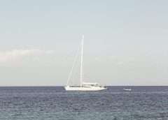 white yacht on sea under blue sky